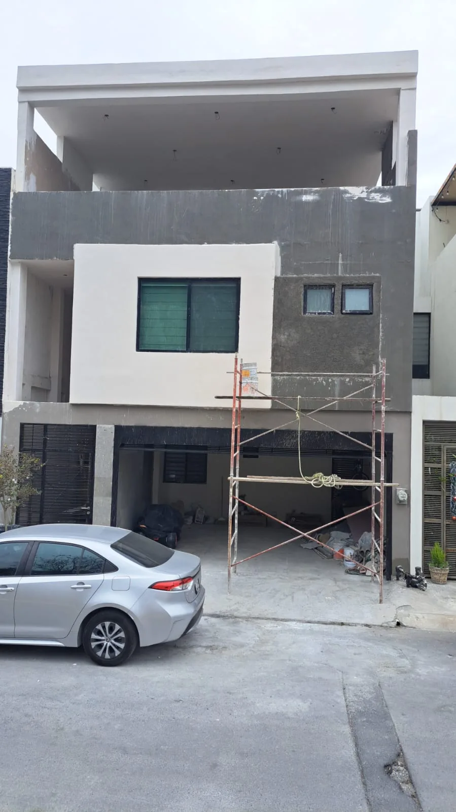 Vivienda habitacional en proceso de terminación y trabajos de fachada.
